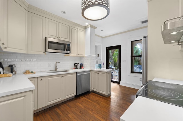 kitchen with visible vents, dark wood-style flooring, a sink, decorative backsplash, and stainless steel appliances