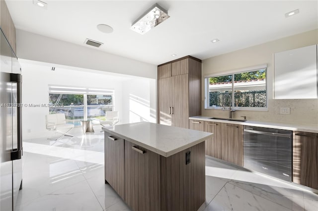 kitchen featuring marble finish floor, stainless steel appliances, modern cabinets, and a sink