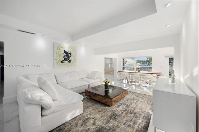 living area with marble finish floor, visible vents, and recessed lighting