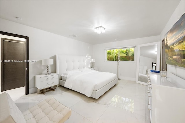 bedroom featuring marble finish floor and baseboards