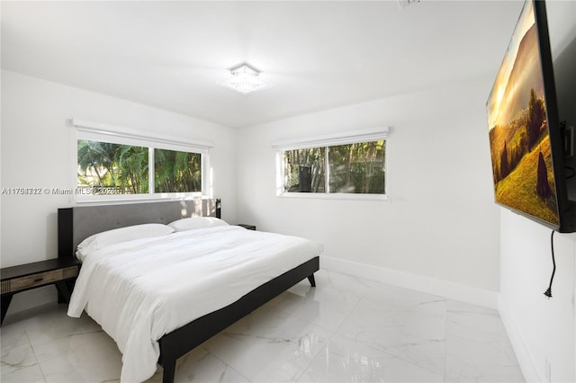 bedroom with marble finish floor and baseboards