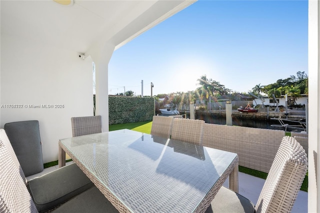 balcony with a water view and outdoor dining space