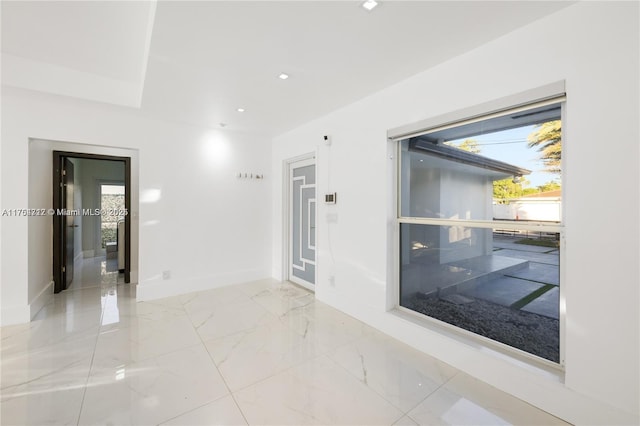 unfurnished room with marble finish floor, baseboards, and recessed lighting