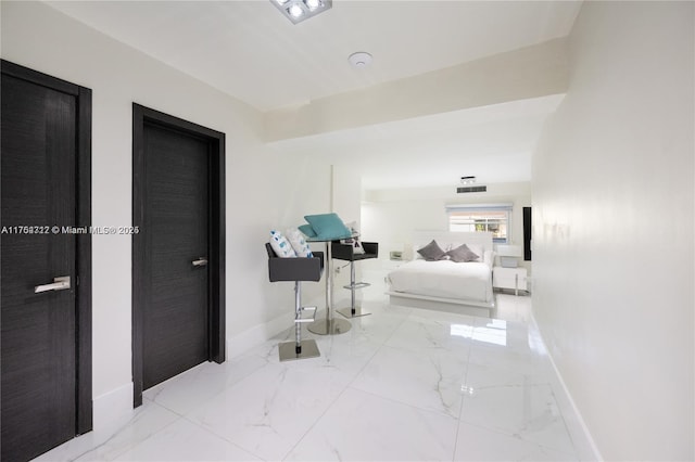 hall with marble finish floor, visible vents, and baseboards