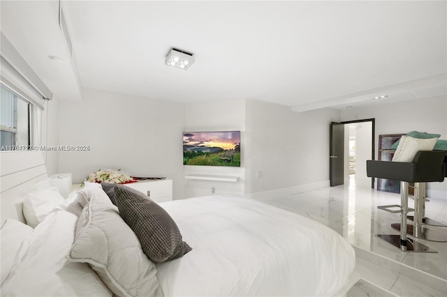 bedroom featuring marble finish floor, multiple windows, and baseboards