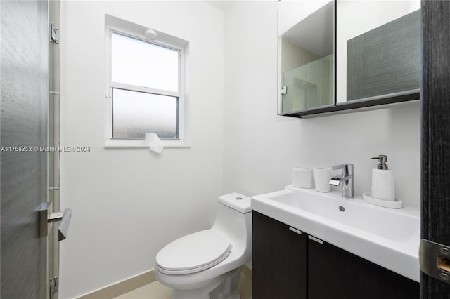 bathroom with an enclosed shower, vanity, and toilet