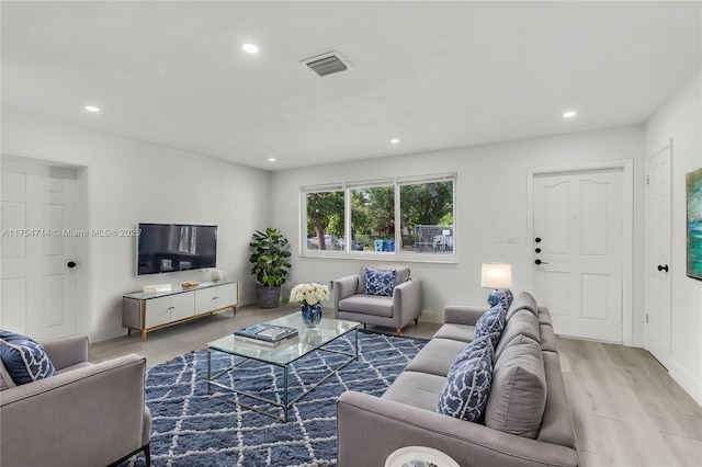 living area with wood finished floors, visible vents, and recessed lighting