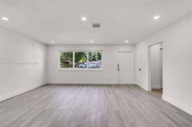 unfurnished room featuring baseboards, light wood finished floors, visible vents, and recessed lighting