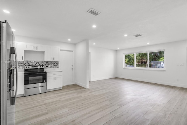 kitchen featuring tasteful backsplash, visible vents, appliances with stainless steel finishes, open floor plan, and white cabinetry