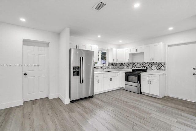 kitchen with stainless steel fridge, visible vents, electric stove, light countertops, and a sink