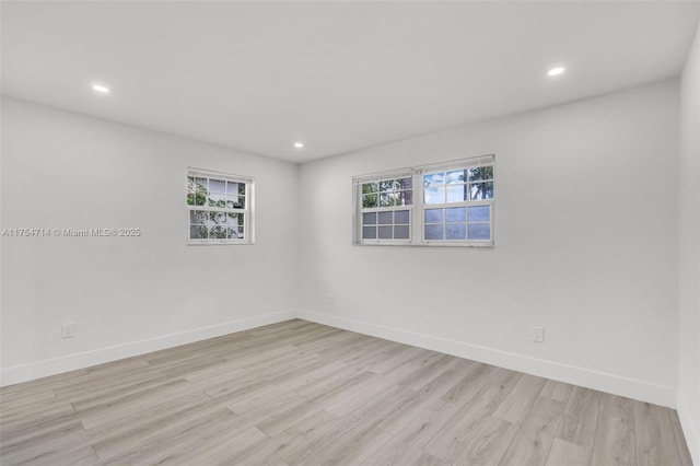 empty room featuring recessed lighting, light wood-type flooring, and baseboards