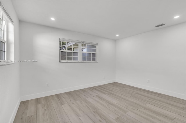 empty room featuring baseboards, visible vents, wood finished floors, and recessed lighting