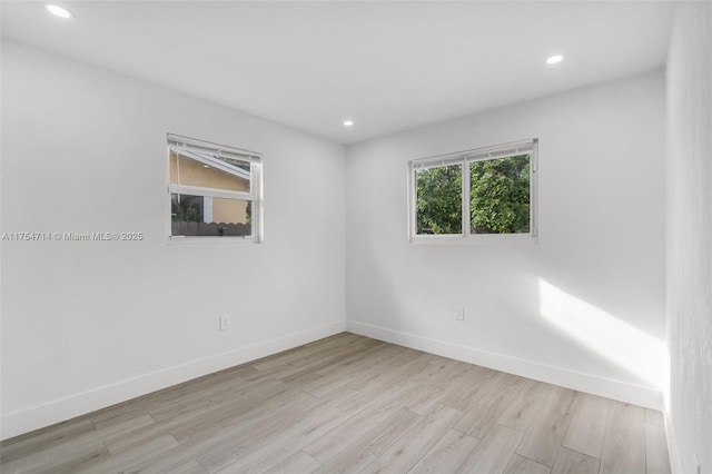 empty room with baseboards, recessed lighting, and light wood-style floors