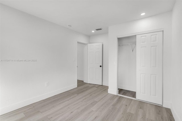 unfurnished bedroom with light wood-style floors, visible vents, and baseboards