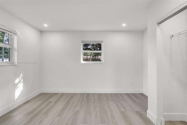 unfurnished room featuring recessed lighting, light wood-type flooring, and baseboards