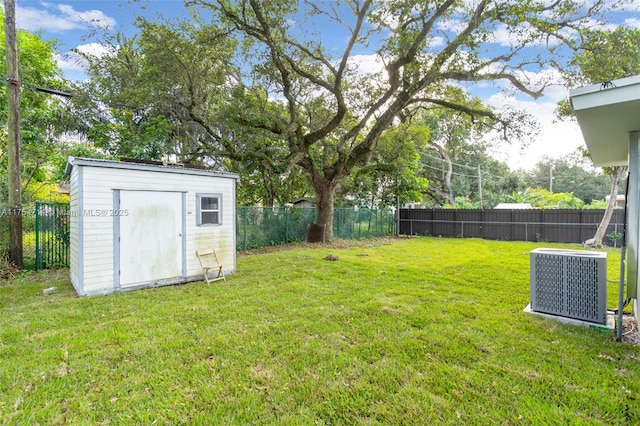 view of yard featuring a storage shed, a fenced backyard, an outdoor structure, and cooling unit