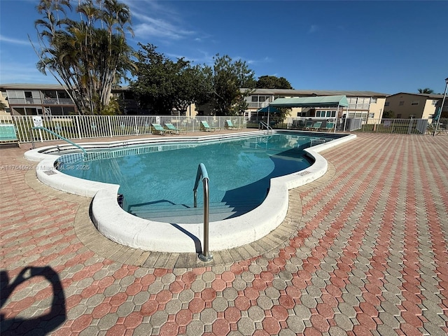 pool with a patio area and fence