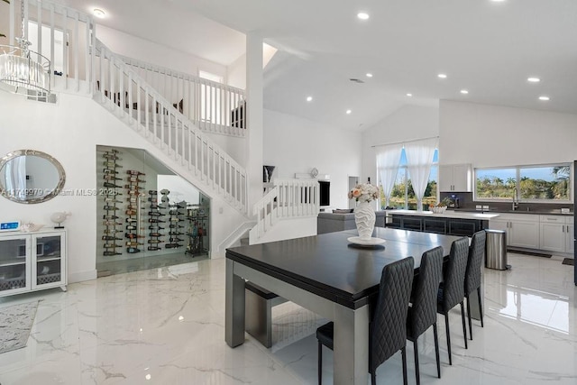 dining room featuring high vaulted ceiling, recessed lighting, marble finish floor, and stairs