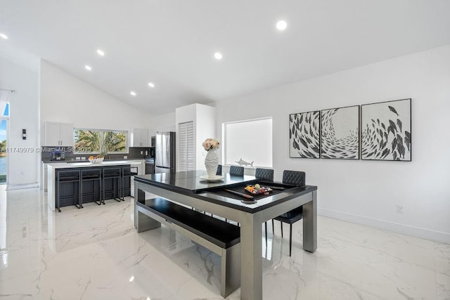 dining space featuring baseboards, marble finish floor, and recessed lighting