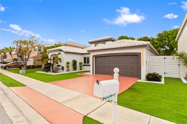 mediterranean / spanish-style house with concrete driveway, a tile roof, an attached garage, a front yard, and stucco siding