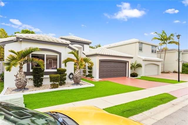 mediterranean / spanish-style home with a garage, a tiled roof, a front lawn, and stucco siding