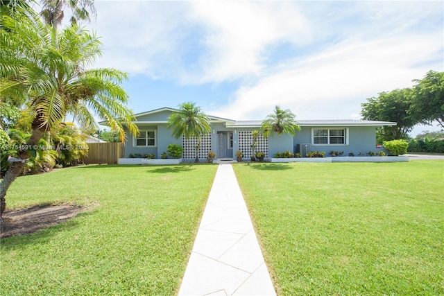 ranch-style house featuring fence, a front lawn, and stucco siding