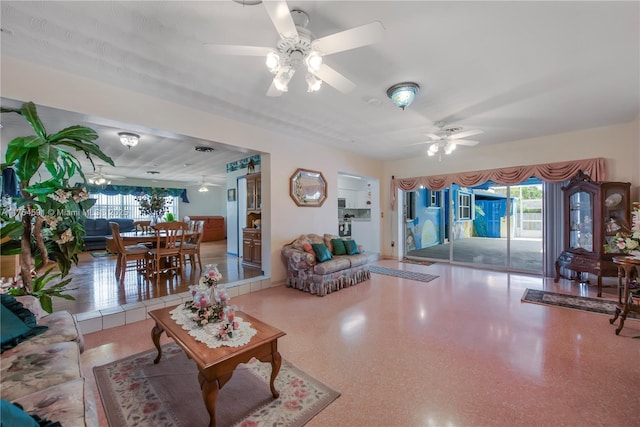 living room featuring a ceiling fan and speckled floor