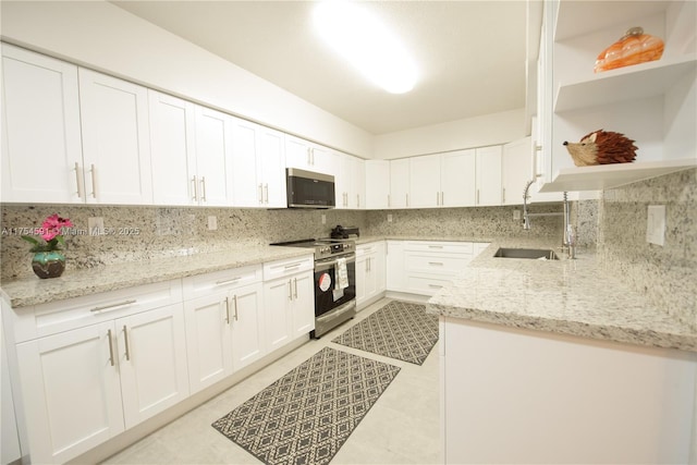 kitchen with a sink, stainless steel appliances, backsplash, and open shelves