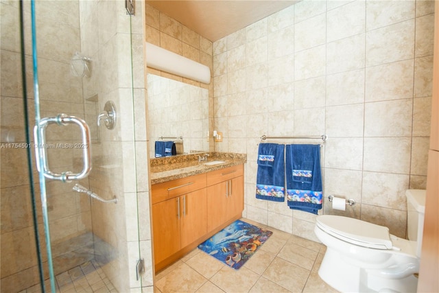 bathroom with toilet, a shower stall, tile walls, and tile patterned floors