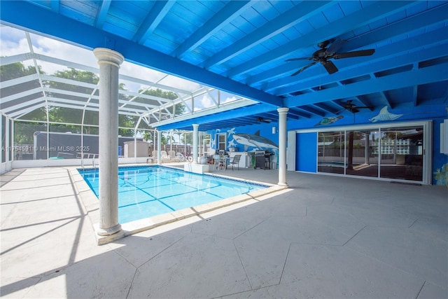 outdoor pool featuring a patio, glass enclosure, and a ceiling fan