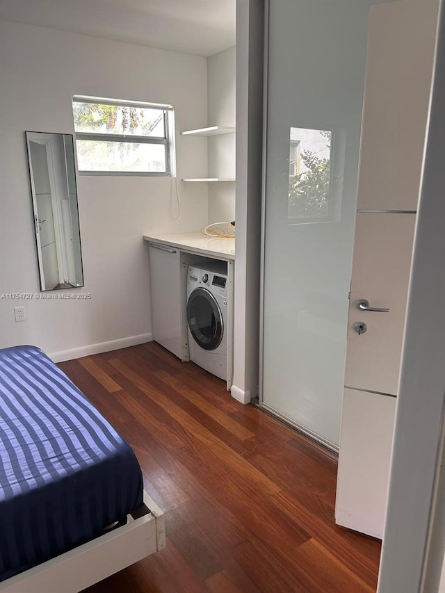 laundry room featuring washer / dryer, baseboards, laundry area, and wood finished floors