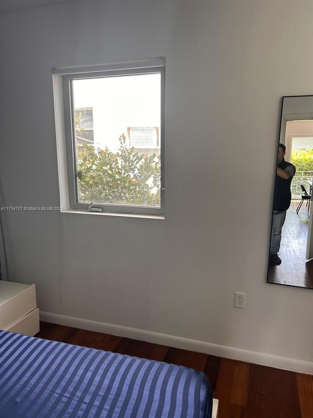 bedroom with dark wood-style floors and baseboards