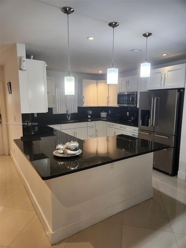 kitchen featuring appliances with stainless steel finishes, tasteful backsplash, a sink, and light tile patterned floors