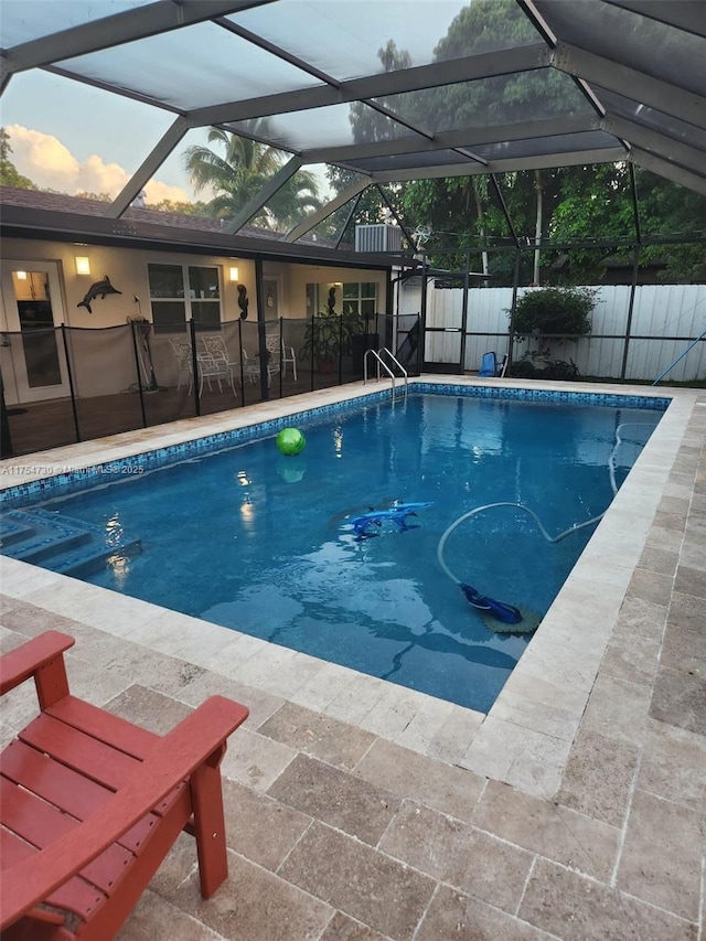 view of swimming pool with a fenced in pool, a lanai, fence, and a patio