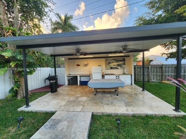 parking at dusk featuring a yard, a fenced backyard, and ceiling fan