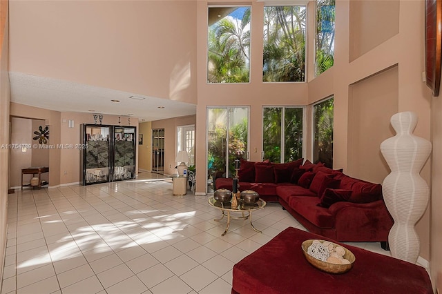 living area featuring a high ceiling and light tile patterned flooring
