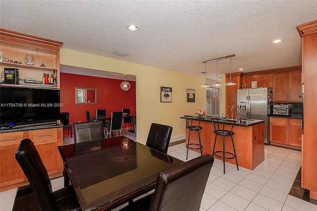 dining room with visible vents, a textured ceiling, a toaster, and light tile patterned flooring