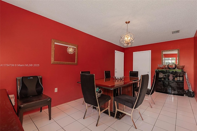 dining room with visible vents, a textured ceiling, light tile patterned floors, and a chandelier