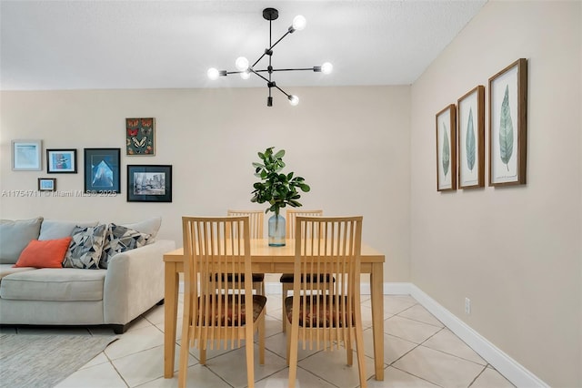 dining area with baseboards, a textured ceiling, light tile patterned flooring, and a notable chandelier