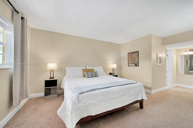 bedroom featuring light carpet, baseboards, and a textured ceiling