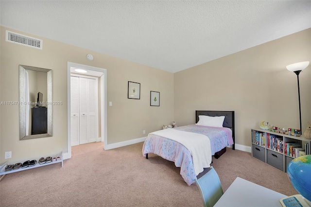 bedroom with carpet, visible vents, a textured ceiling, and baseboards