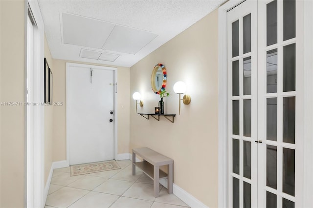 foyer featuring baseboards and light tile patterned floors