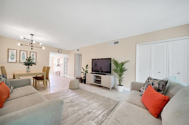 living area featuring light tile patterned flooring, visible vents, and an inviting chandelier