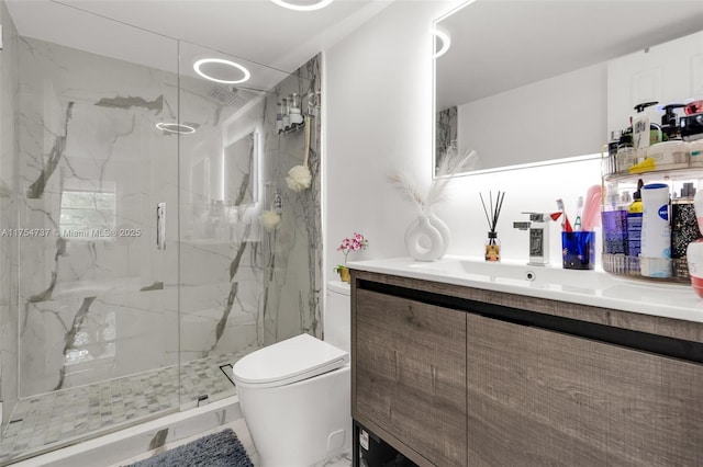 full bathroom with vanity, a marble finish shower, and toilet