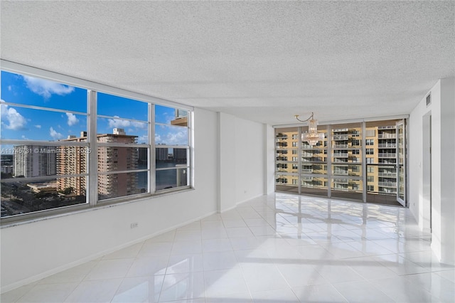 empty room with a view of city, visible vents, a textured ceiling, and tile patterned floors