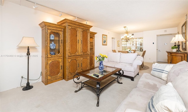 living room with a notable chandelier, a textured ceiling, and light colored carpet