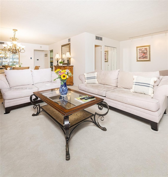 living room with carpet floors, visible vents, a textured ceiling, and an inviting chandelier