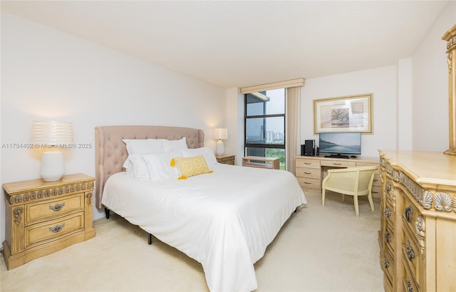 bedroom with a wall of windows and light carpet