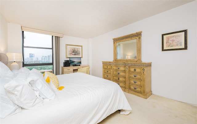 bedroom with light colored carpet and a textured ceiling