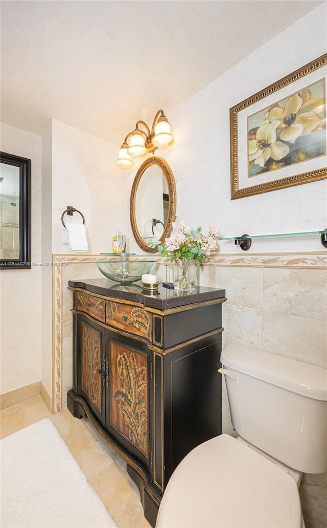 bathroom featuring toilet, tile patterned flooring, tile walls, and vanity